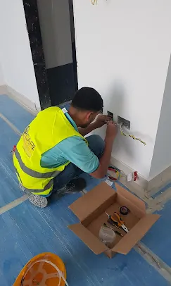 IP Care technician terminating faceplate cabling in a finished apartment at Al Jeel Tower