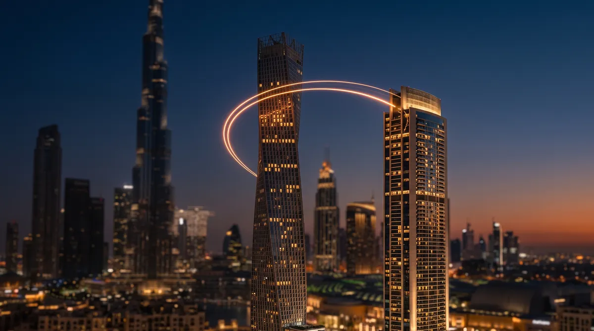 A thin arc of orange light trailing between two silhouetted Dubai towers at dusk